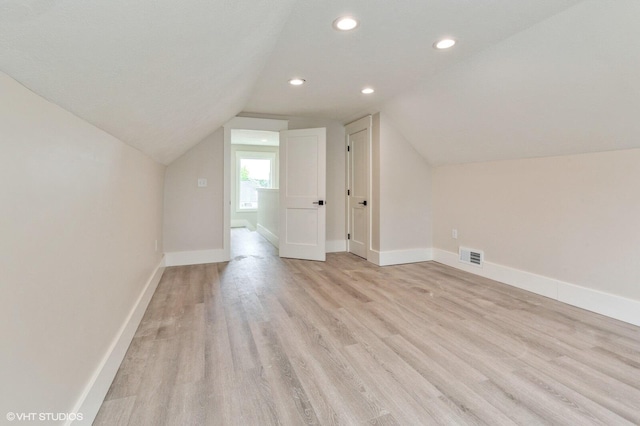 bonus room featuring vaulted ceiling and light hardwood / wood-style flooring