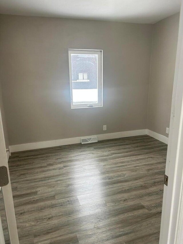 unfurnished room featuring dark wood-type flooring