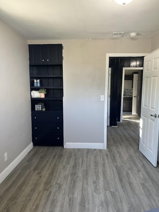 unfurnished room with dark wood-type flooring