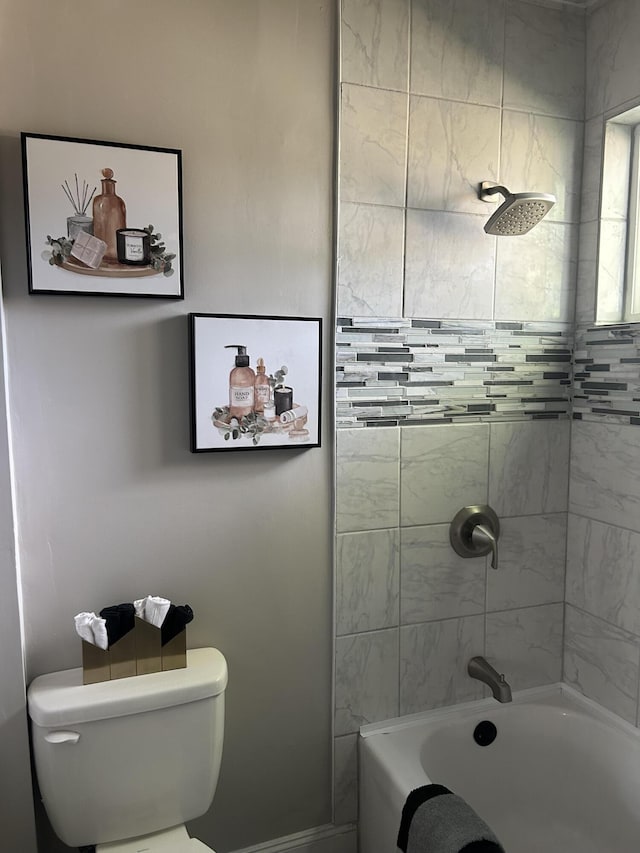 bathroom with toilet and tiled shower / bath