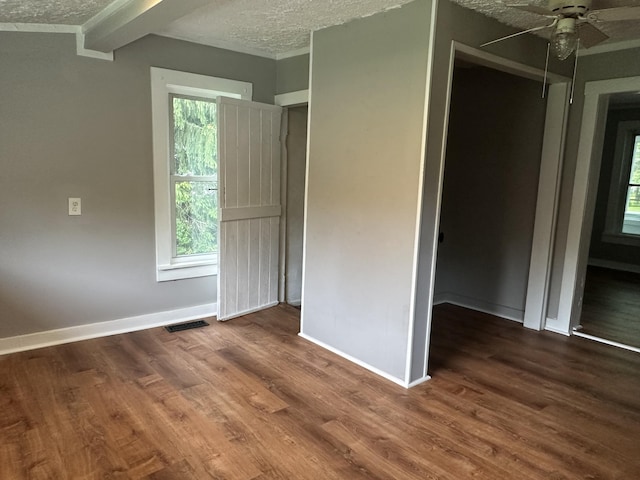 unfurnished bedroom featuring dark wood-type flooring, a textured ceiling, and ceiling fan