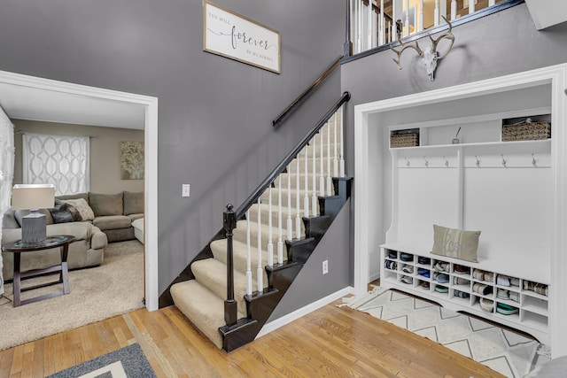 mudroom with a high ceiling and wood-type flooring