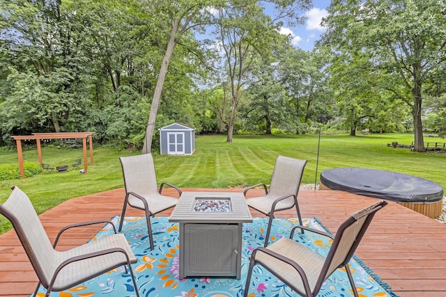 wooden terrace featuring a storage shed, a fire pit, and a yard