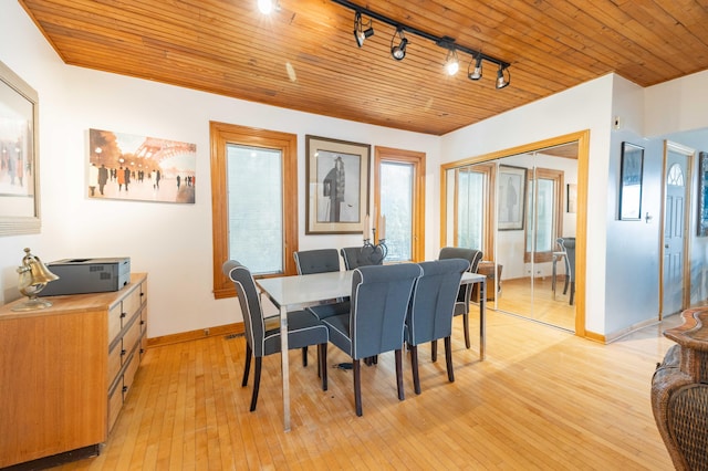 dining room with light hardwood / wood-style flooring, track lighting, and wood ceiling