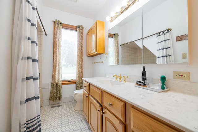 bathroom featuring curtained shower, toilet, and vanity