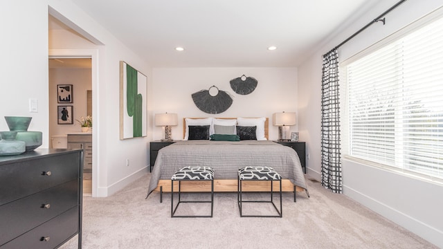 bedroom with light carpet and ensuite bathroom