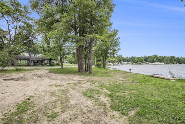 view of yard featuring a water view and a dock