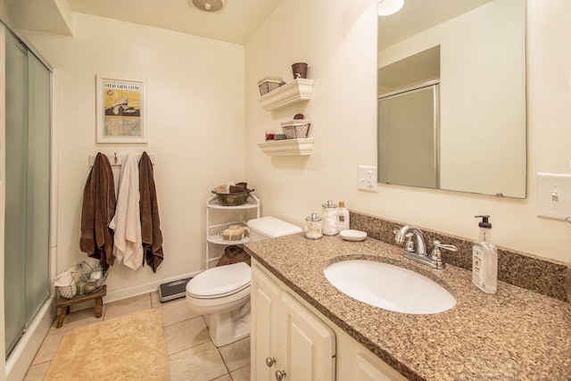 bathroom with an enclosed shower, vanity, tile patterned floors, and toilet