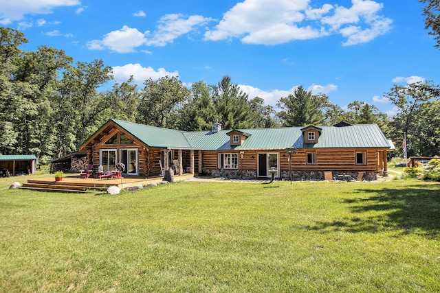 rear view of property featuring a yard and a deck