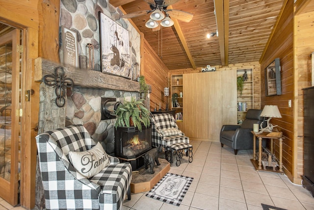 sitting room featuring wood ceiling, light tile patterned floors, wooden walls, beamed ceiling, and ceiling fan