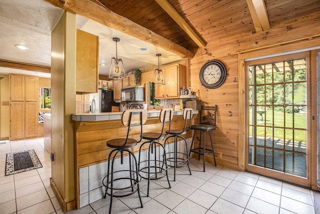 kitchen featuring beam ceiling, wooden walls, decorative light fixtures, wooden ceiling, and kitchen peninsula