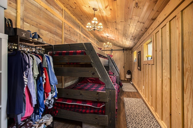 bedroom featuring dark hardwood / wood-style floors, wood walls, lofted ceiling, a chandelier, and wood ceiling