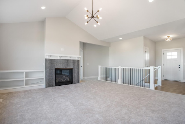 unfurnished living room with an inviting chandelier, built in features, a fireplace, and carpet