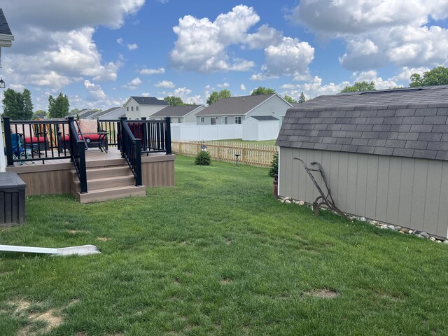 view of yard with a deck and a storage shed