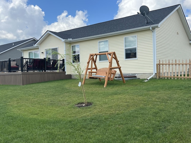 rear view of house with a lawn and a deck