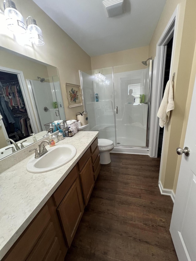 bathroom with vanity, hardwood / wood-style flooring, toilet, and walk in shower