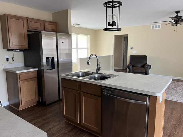 kitchen featuring a center island with sink, sink, ceiling fan, appliances with stainless steel finishes, and dark hardwood / wood-style flooring