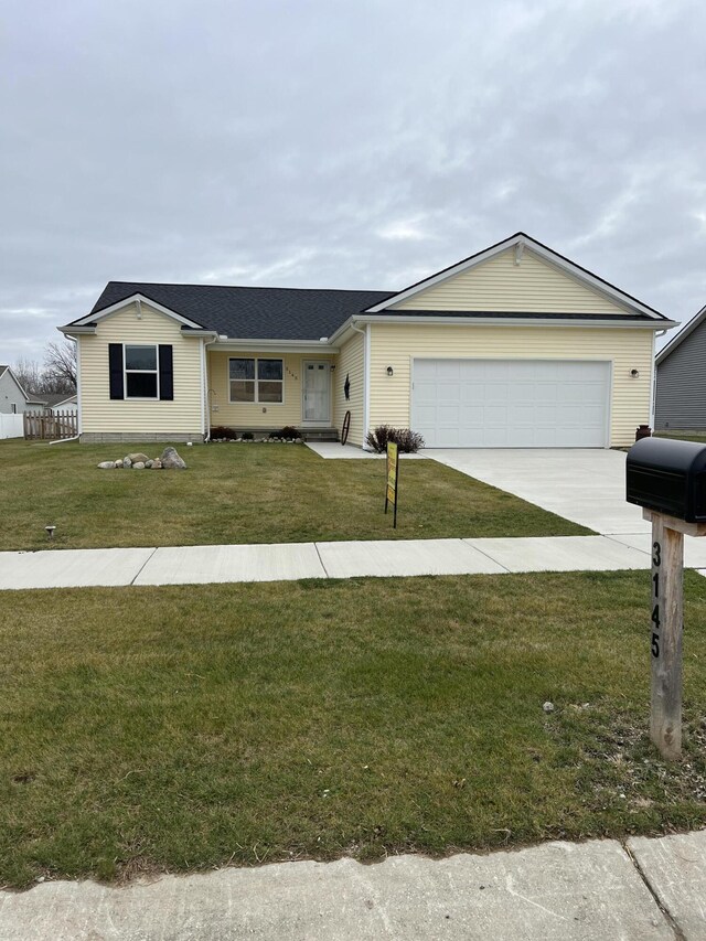 single story home featuring a garage and a front yard