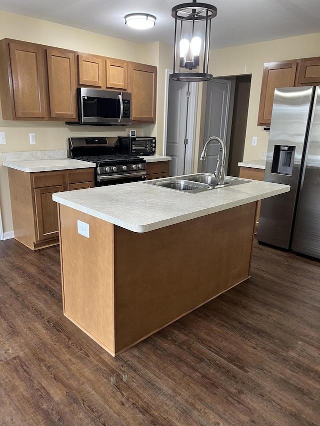 kitchen with dark hardwood / wood-style floors, a kitchen island with sink, sink, and appliances with stainless steel finishes