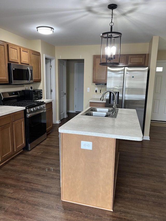 kitchen with appliances with stainless steel finishes, sink, dark hardwood / wood-style floors, and an island with sink