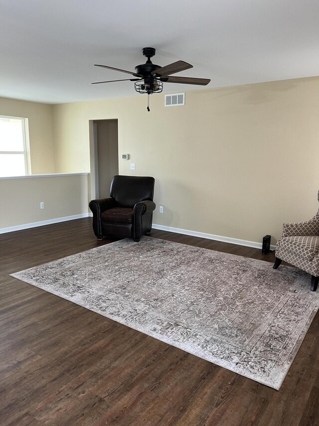 living area with dark hardwood / wood-style floors and ceiling fan