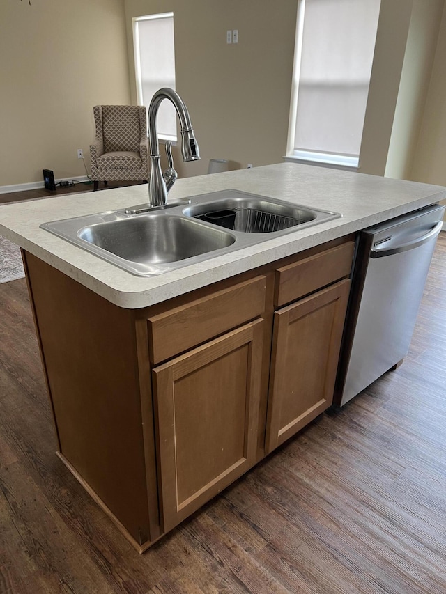 kitchen featuring a center island with sink, dishwasher, dark hardwood / wood-style flooring, and sink