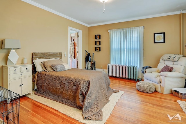 bedroom with light hardwood / wood-style flooring, radiator, and ornamental molding