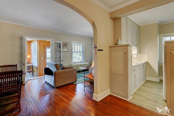 living room featuring hardwood / wood-style flooring, crown molding, and radiator