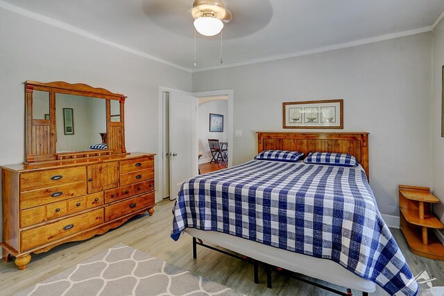 bedroom with ceiling fan, crown molding, and light hardwood / wood-style flooring