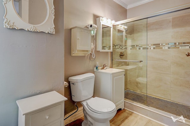 bathroom with toilet, an enclosed shower, crown molding, and vanity