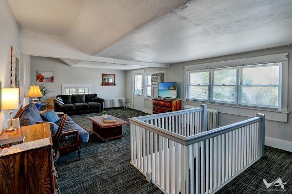 carpeted living room featuring radiator heating unit and a textured ceiling