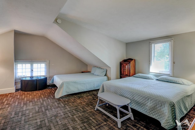 carpeted bedroom with vaulted ceiling and multiple windows