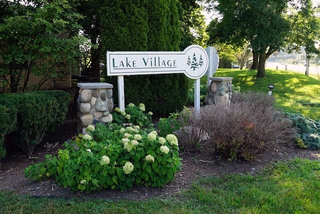 community / neighborhood sign featuring a yard