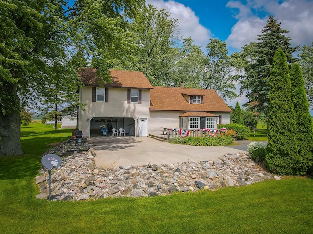 rear view of house with a lawn and a garage