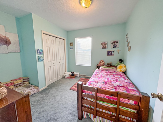 carpeted bedroom with a closet and a textured ceiling