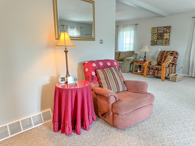 living area featuring carpet floors and beam ceiling