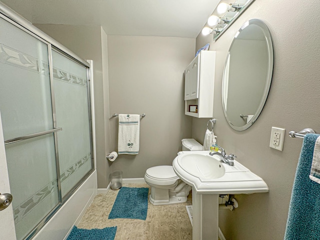 bathroom featuring combined bath / shower with glass door, toilet, and tile patterned flooring