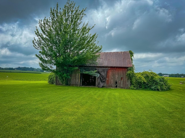 view of outbuilding with a rural view and a yard