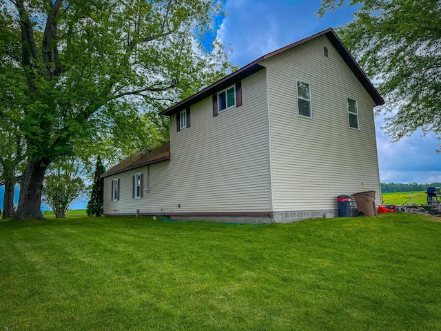 view of side of home with a yard