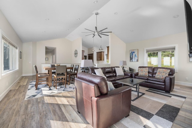 living room with vaulted ceiling, light hardwood / wood-style floors, and ceiling fan