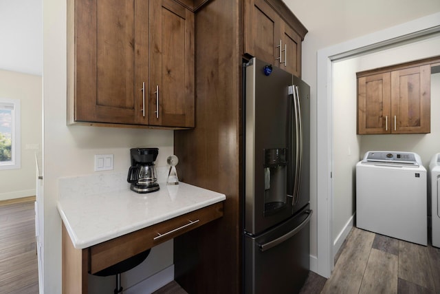 kitchen featuring washing machine and dryer, stainless steel fridge, and light wood-type flooring