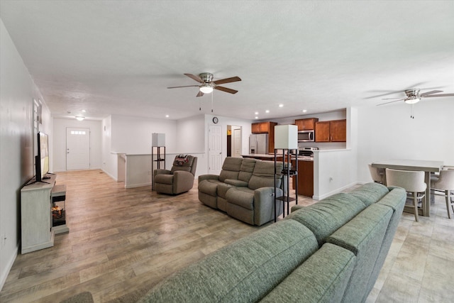 living room with ceiling fan and light hardwood / wood-style floors