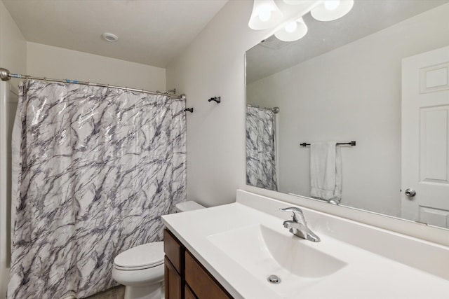 bathroom with vanity, toilet, and curtained shower