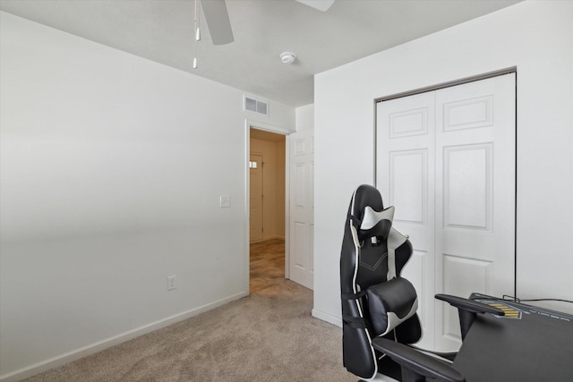 carpeted office space featuring ceiling fan