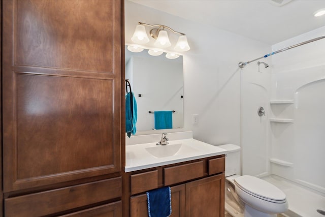 bathroom featuring toilet, vanity, and walk in shower