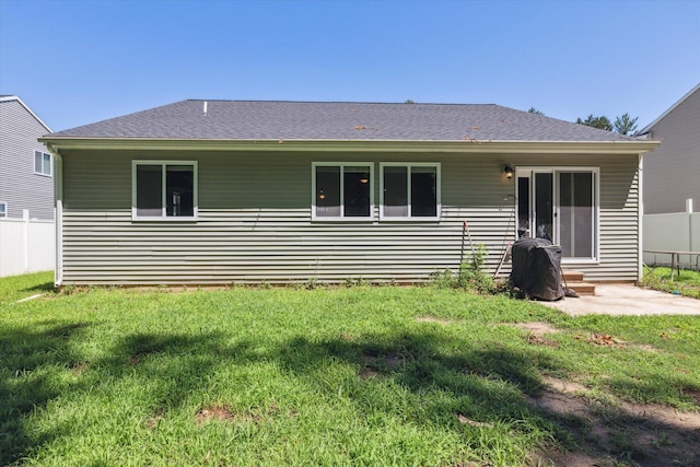 rear view of property featuring a lawn