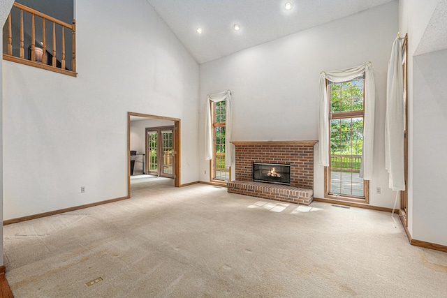 unfurnished living room with light colored carpet, a fireplace, and high vaulted ceiling