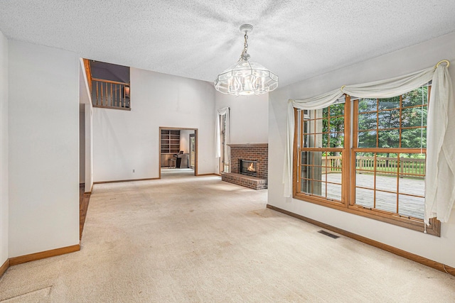 unfurnished living room with carpet, an inviting chandelier, a textured ceiling, and a fireplace