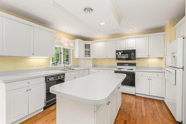 kitchen featuring white cabinetry, hardwood / wood-style floors, black appliances, and a center island