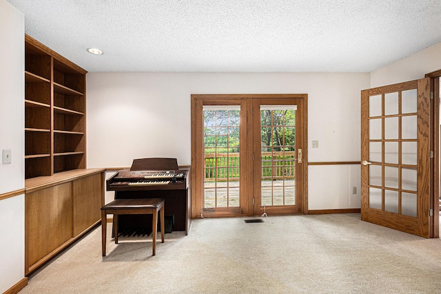 miscellaneous room with light carpet, a textured ceiling, and french doors